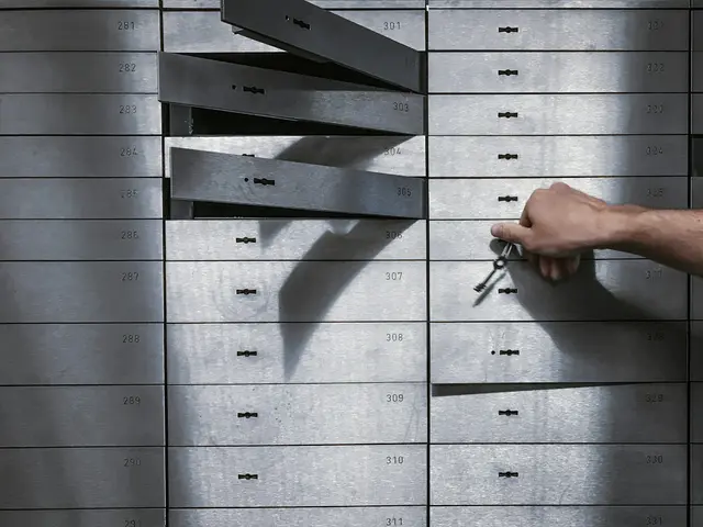 Hand turning a key in a safe deposit locker